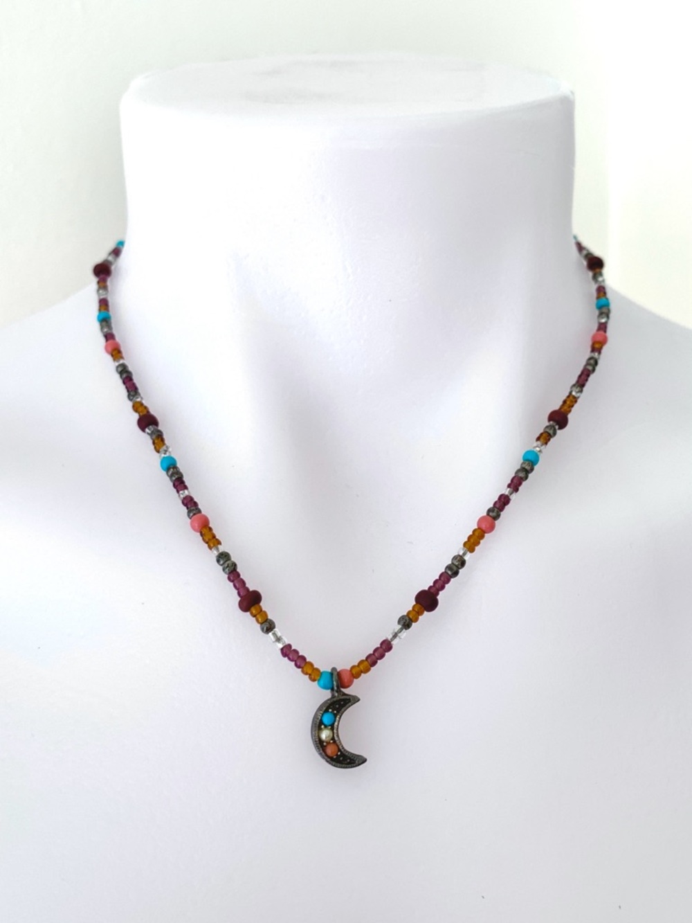 Dark colorful beaded necklace with silver tone crescent moon charm pendant